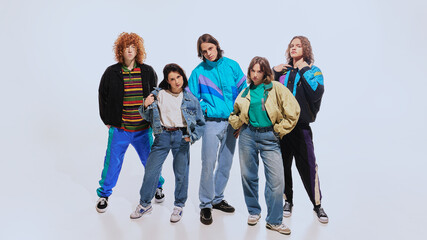 Stylish young men and women in trendy retro-inspired outfits, including windbreakers, high-waisted...