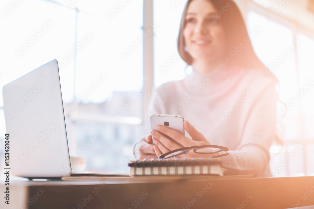 Poster selective focus on laptop computer and mobile phone, positive software developer spending time with 
