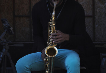 Person sitting playing saxophone, jazz music, solo