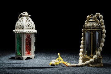 Arabic lanterns and prayer beads on a black background. Decoration for Muslim holidays celebration