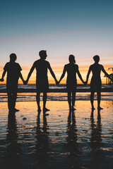 Silhouette of the people holding hands enjoying vacation together standing on ocean sandy beach in evening dusk, group of male and female persons. Happiness, success, friendship, community concept