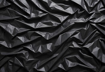Obraz premium Crumpled black plastic sheets , creating an abstract textured background