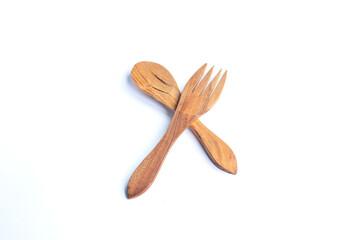 Eco-friendly wooden spoon and fork crossed on a white background, highlighting natural and minimalist tableware