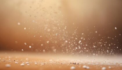 Fototapeta premium A close-up view of falling snow or dust particles against a blurred, warm-toned background