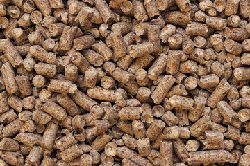 Wood pellet cat litter as background, closeup. Pressed wood, large granules. Pellets. A pile of wood granules. Texture. Wood filler for cat toilet, top view. Hygienic filler for pets