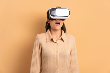 surprised brunette young woman Using VR headset and gesturing in studio shot. virtual reality, technology simulation concept.