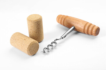Corkscrew with wooden handle and corks on white background