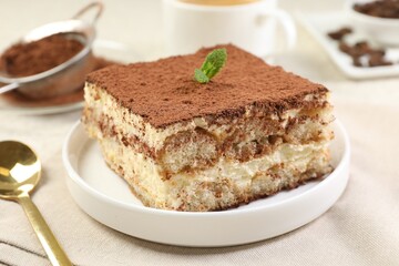 Delicious tiramisu with mint on light table, closeup