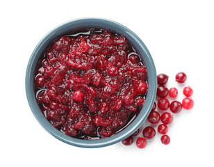Tasty cranberry sauce in bowl and berries isolated on white, top view