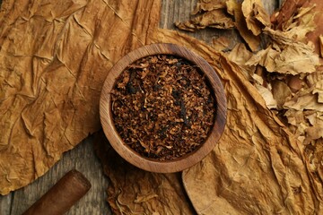 Tobacco, dried leaves and cigar on wooden table, flat lay