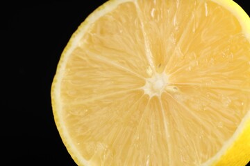 Half of fresh lemon on black background, closeup