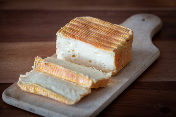 Sliced Limburger or Herve cheese on wooden plank