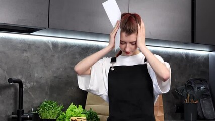 In a modern kitchen, a young chef experiences frustration while trying to organize her workspace. Surrounded by fresh vegetables, she contemplates her next step amid the mess.