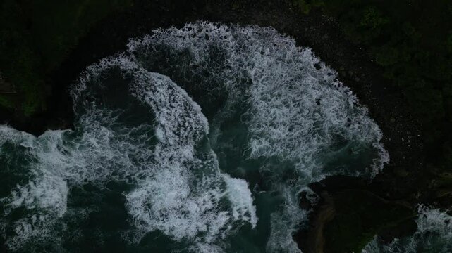 Aerial slow-motion footage of foamy sea waves on Menganti Beach in Kebumen, Java, Indonesia