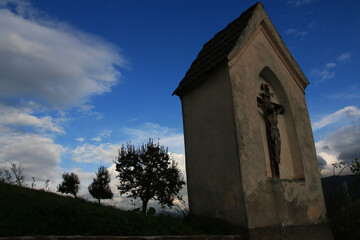 kleine Kapelle mit Christus Kreuz in mystischer Stimmung spät am Abend gegen den Himmel