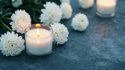 Serene candles surrounded by white flowers on a textured surface.