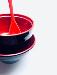 Red ceramic spoon with red bowls on white background