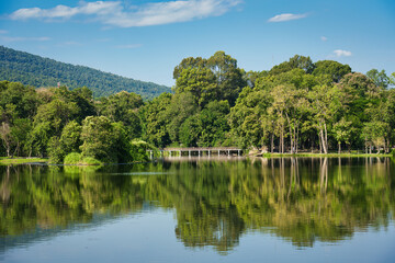 Fototapeta premium Ang Kaew reservoir with forest and lake reflection on sunny day