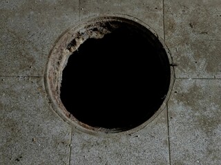 Hazard Underfoot: Open Manhole on Concrete Floor