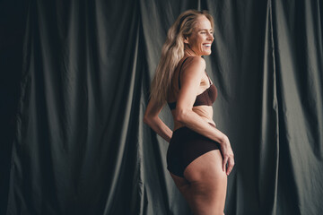 Studio no retouch photo of positive slender lady dressed lingerie accepting her age isolated khaki...