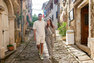 A couple walks around a small medieval town in the Mediterranean country