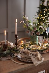 Christmas celebration. Festive table setting with dishware, glasses and decor in room
