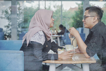 Dating in a cafe. Beautiful Asian lover couple sitting in a cafe enjoying in coffee and conversation. Love and romance