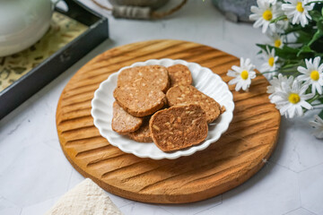 A close-up view of delicious chocolate almond cookies neatly arranged on a white plate.  A popular cookies in Malaysia during Eid Mubarak (Hari Raya)