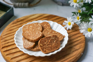 A close-up view of delicious chocolate almond cookies neatly arranged on a white plate.  A popular cookies in Malaysia during Eid Mubarak (Hari Raya)