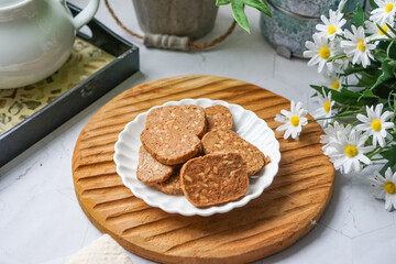 A close-up view of delicious chocolate almond cookies neatly arranged on a white plate.  A popular cookies in Malaysia during Eid Mubarak (Hari Raya)