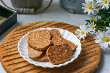 A close-up view of delicious chocolate almond cookies neatly arranged on a white plate.  A popular cookies in Malaysia during Eid Mubarak (Hari Raya)
