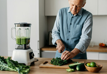 Retired man cutting kale for a green detox smoothie in the kitchen