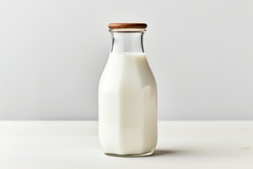 A vintage-style glass milk bottle filled with whole milk, surrounded by a soft shadow on a pure white backdrop