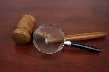 Bad legal system concept. Broken judge gavel under magnifying glass.	