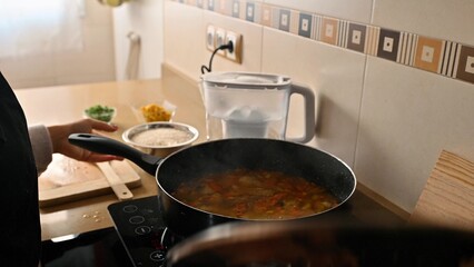 Cooking a Delicious Vegetarian Paella in a Home Kitchen with Fresh Ingredients
