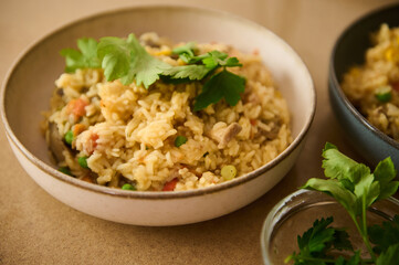 Delicious vegetable paella garnished with fresh parsley in ceramic bowl
