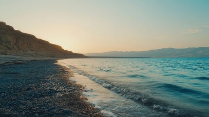 breathtaking natural landscape of dead sea shoreline during golden hour with mineral-rich waters and dramatic mountain horizon