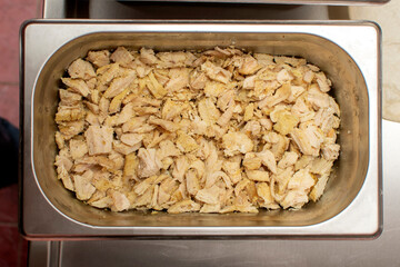Top view of a roasted chiken in stainless steel food container
