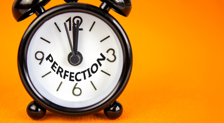 Perfection symbol. Concept word Perfection on beautiful orange paper. Beautiful orange paper background. Black alarm clock. Business perfection concept. Copy space.