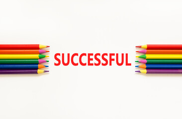 Fototapeta premium Successful symbol. Concept word Successful on beautiful white paper. Beautiful white paper background. Beautiful colored pencils. Business successful concept. Copy space.