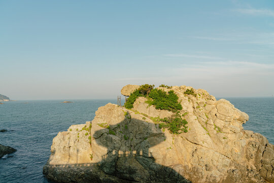 Busan, South Korea - May 25, 2017: the shadow of Songiljeong Pavilion in Jukdo Park at the end of Songjeong Beach, cast on the rock.