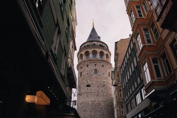 Galata Tower, a medieval stone tower, standing tall between buildings in Istanbul, Turkey, a popular tourist destination