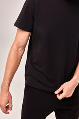 Casual black t-shirt worn by person, showcasing simple modern clothing, everyday style concept