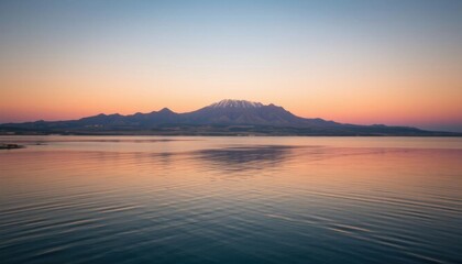 mountain in the distance with a body of water in the foreground