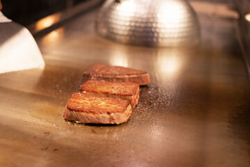 Grilled meat sizzling on a hot plate.