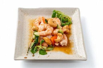 plate of cooked shrimp with cashew nuts and vegetables centered on white background