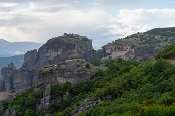 Meteora monasteries on the tops of rocks in the mountains. Interesting shaped rock formations in Greece. Beautiful mountain landscape.