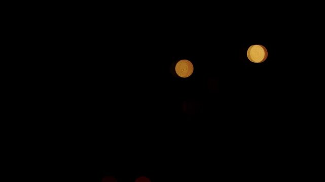 plan fixe avec des billes de bokeh cr&eacute;ent par les voitures roulant sur l'autoroute, de nuit, les grands d&eacute;parts pour les vacances