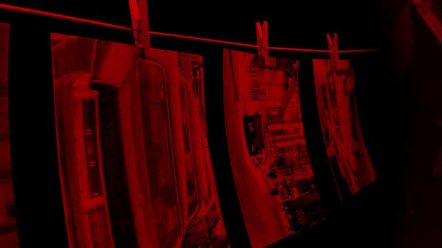 Photograph Prints Hanging In Dark Room