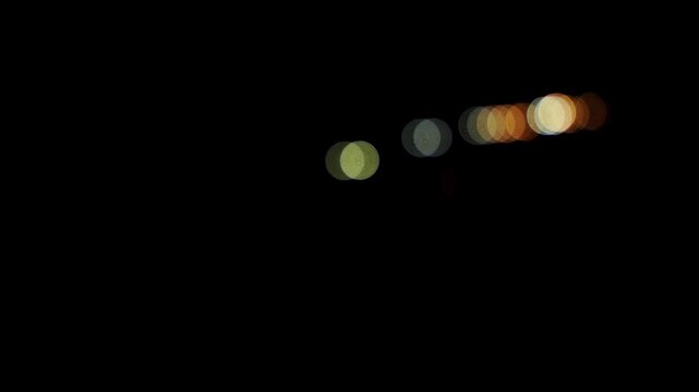 plan fixe avec des billes de bokeh cr&eacute;ent par les voitures roulant sur l'autoroute, se croisant de nuit, ce qui annonce les grands d&eacute;parts pour les vacances !